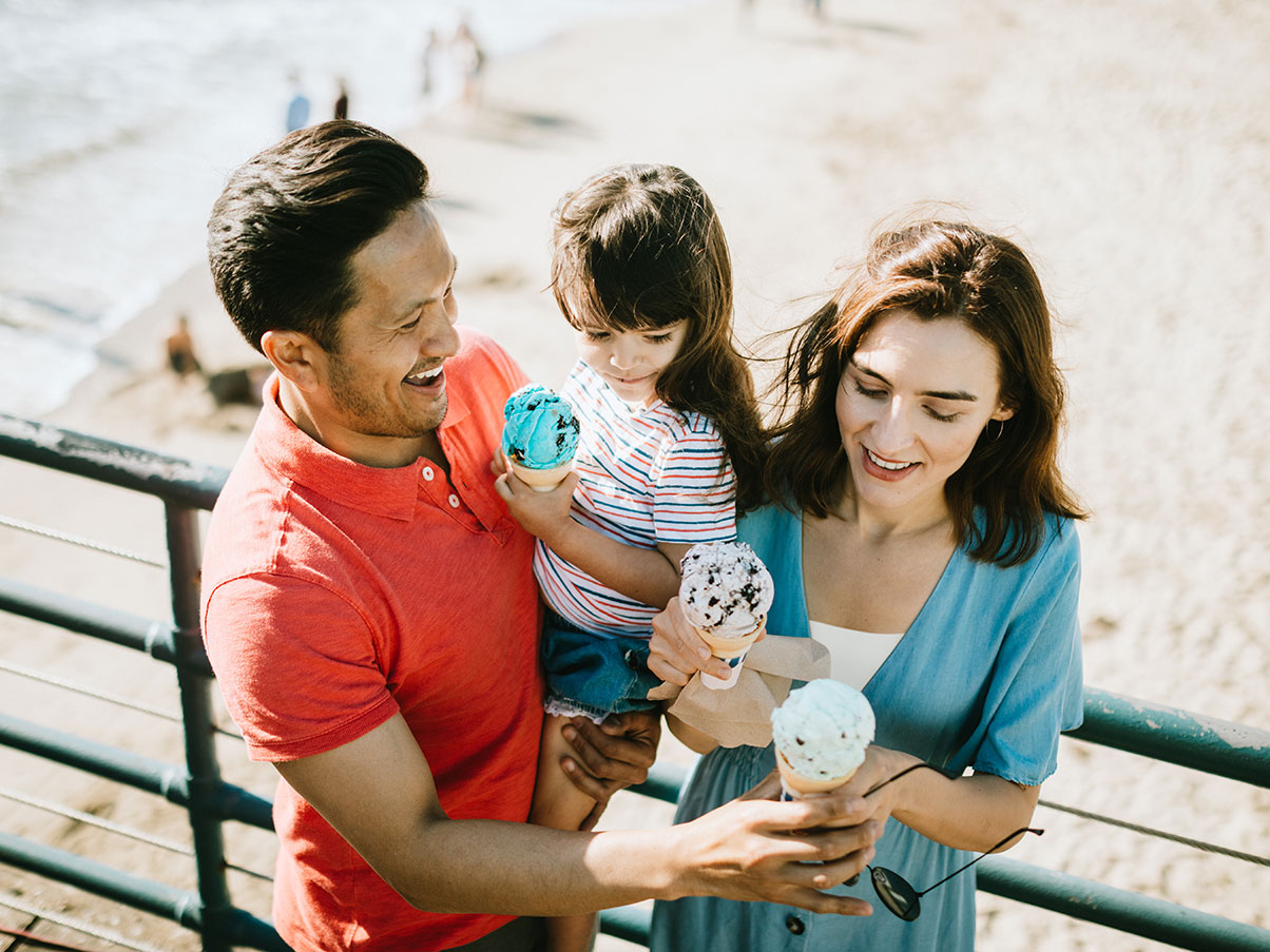 photo of tourist family having ice cream at the beach